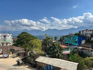 a city with buildings and mountains in the background at BeeHive Homestay in Hāflong