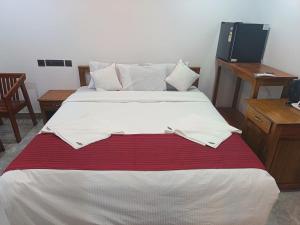 ein großes Bett mit einer rot-weißen Decke in der Unterkunft Romance Resort Varkala in Varkala