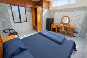 een slaapkamer met een blauw bed en een bureau bij Bình Cơ Hotel in Hoi Nghia