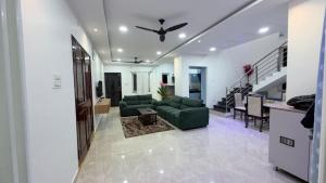 a living room with a couch and a ceiling fan at Elite stays in Rajiv Gandhi International Airport