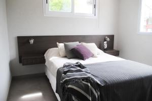 - une chambre avec un grand lit et des oreillers violets dans l'établissement Médano 29 Departamentos en alquiler, à Las Gaviotas