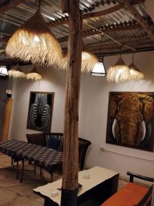 een kamer met tafels en schilderijen aan de muur bij pole inn villa in Kinyasini