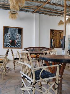 een kamer met stoelen en tafels en schilderijen aan de muren bij pole inn villa in Kinyasini