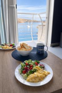 een tafel met twee borden eten en een salade bij SEApartment MALLTA'MR in St Paul's Bay