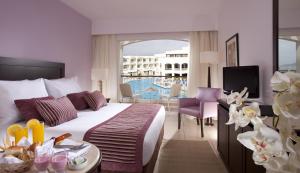 um quarto de hotel com uma cama e uma varanda em Jaz Sharks Bay em Sharm el Sheikh