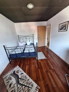 een slaapkamer met een bed en een houten vloer bij Ferienwohnung Karin in Schwaz