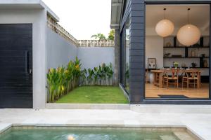 een huis met een zwembad en een patio bij Black Villa by Betterplace in Tanah Lot