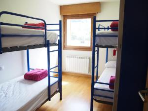 two bunk beds in a room with a window at Albergue Segunda Etapa in Zubiri