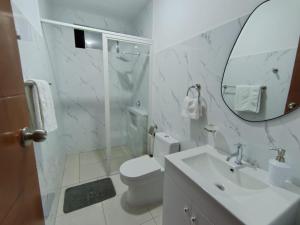 a bathroom with a toilet and a sink and a mirror at koi Residencial 301 in Chimbote