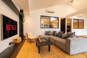 een woonkamer met een bank en een tafel bij Black Villa by Betterplace in Tanah Lot