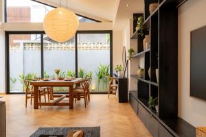 een eetkamer met een tafel en een groot raam bij Black Villa by Betterplace in Tanah Lot