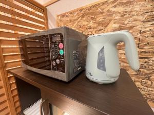 een magnetron op een tafel naast een koffiezetapparaat bij Minpaku MATSURI 民泊まつり in Tanabe