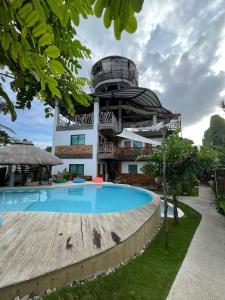 a building with a swimming pool in front of a building at The Hat Trick Hostel in Basdiot +59 photos