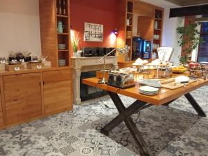 a kitchen with a wooden table with food on it at The Originals Boutique, Grand Hôtel Saint-Pierre, Aurillac in Aurillac