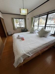 a bedroom with a large bed with two towels on it at Sugi Mountain House in Myoko