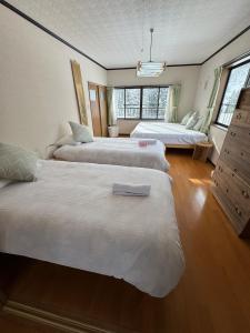 a room with three beds in a room at Sugi Mountain House in Myoko