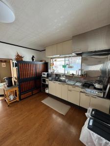 a kitchen with stainless steel appliances and wooden floors at Sugi Mountain House in Myoko