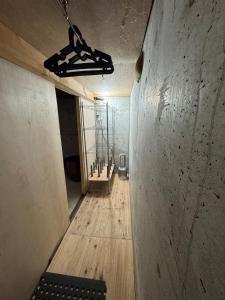 an empty room with a wooden floor and a light fixture at Sugi Mountain House in Myoko