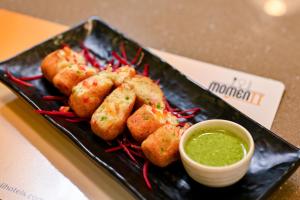 a plate of food with shrimp and a dipping sauce at Enrise by Sayaji, Vadodara in Vadodara