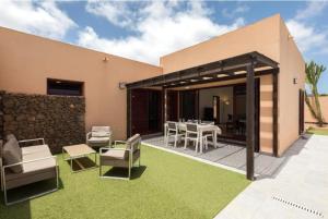 a house with a patio with a table and chairs at Tajora House by Best Holidays Fuerteventura in La Oliva