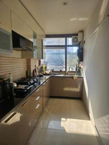 a large kitchen with a sink and a window at Independent Floor in Gurgaon