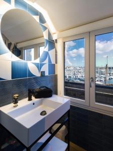 een badkamer met een witte wastafel en een raam bij ibis Styles Saint Malo Centre Historique in Saint-Malo