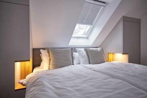 een slaapkamer met een groot wit bed en een dakraam bij Die-perfekte-Ferienvilla in Butjadingen
