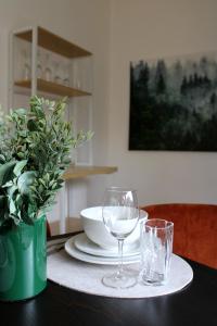 a table with two wine glasses and a vase on it at GlückAufBud Schwarzenberg WLAN Netflix Stellplatz in Schwarzenberg/Erzgebirge +11 photos
