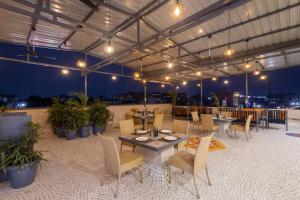 een dakterras met tafels, stoelen en verlichting bij Pravasa Stay Near Luv Kush Square in Indore