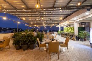 een restaurant met tafels en stoelen op een dak bij Pravasa Stay Near Luv Kush Square in Indore