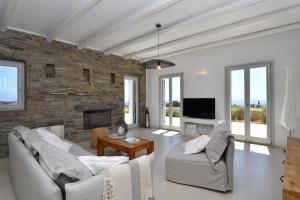 een woonkamer met 2 banken en een bakstenen muur bij Villa Apa Calma in Kampos Paros