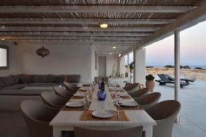een lange eetkamer met een lange tafel en stoelen bij Villa Apa Calma in Kampos Paros