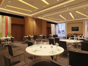 een vergaderzaal met tafels en stoelen en een televisie bij ibis Pune Hinjewadi - An Accor Brand in Pune