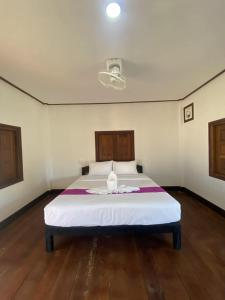 a bedroom with a large white bed in a room at Guesthouse and Restaurant SayLomYen KongLor in Ban Dôn