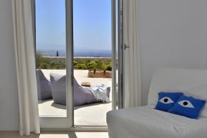een woonkamer met een bank en een glazen schuifdeur bij Villa Apa Calma in Kampos Paros +59 foto's