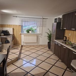 een keuken met een tegelvloer en een raam bij Agroturystyka u Janosika in Bozkow