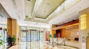 een lobby van een gebouw met een groot plafond bij Jiaxing Fortune Holiday Hotel in Jiaxing