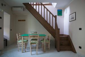 een eetkamer met een tafel en een trap bij Casa Traquandi in Castiglion Fiorentino