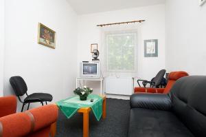 a living room with a couch and chairs and a tv at Abex Hostel in Prague