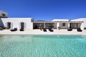 een villa met een zwembad en een aantal stoelen bij Villa Apa Calma in Kampos Paros