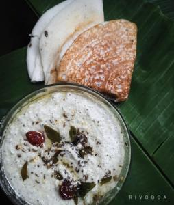 a bowl of food on top of a green leaf at RivoGoa riverside Homestay in Bardez