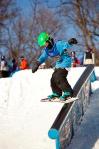 a person riding a snowboard on a rail at Chestnut Mountain Resort in Galena
