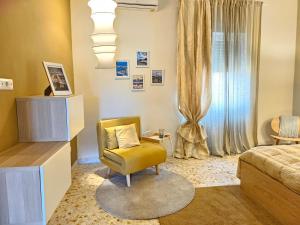een slaapkamer met een gele stoel en een bed bij Sole raggiante Lia Darzillo in Afragola