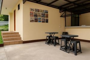 a room with two tables and two stools against a wall at Bahay Domingo Guesthouse & Private Pool in Bagac