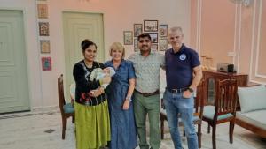 a family posing for a picture in a living room at The Gulmohar Villa in Tājganj