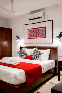 a bedroom with a large bed with a red blanket at Alankara Retreats Colombo 07 in Colombo +40 photos
