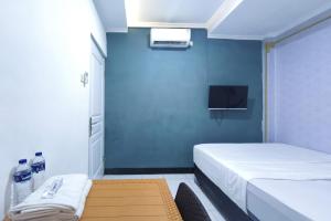 een kleine kamer met een bed en een tv bij INNCA - Dream Memory, Semarang in Kalibanteng-lor