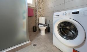 un bagno con lavatrice e WC di Surrounded View Family - with Private Parking a Kavala