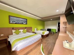 a hotel room with two beds and a flat screen tv at Hotel Candi Indah Akpol Semarang in Semarang