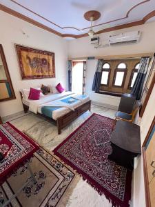 ein Schlafzimmer mit einem Bett und einigen Teppichen in der Unterkunft Golden villa in Jaisalmer